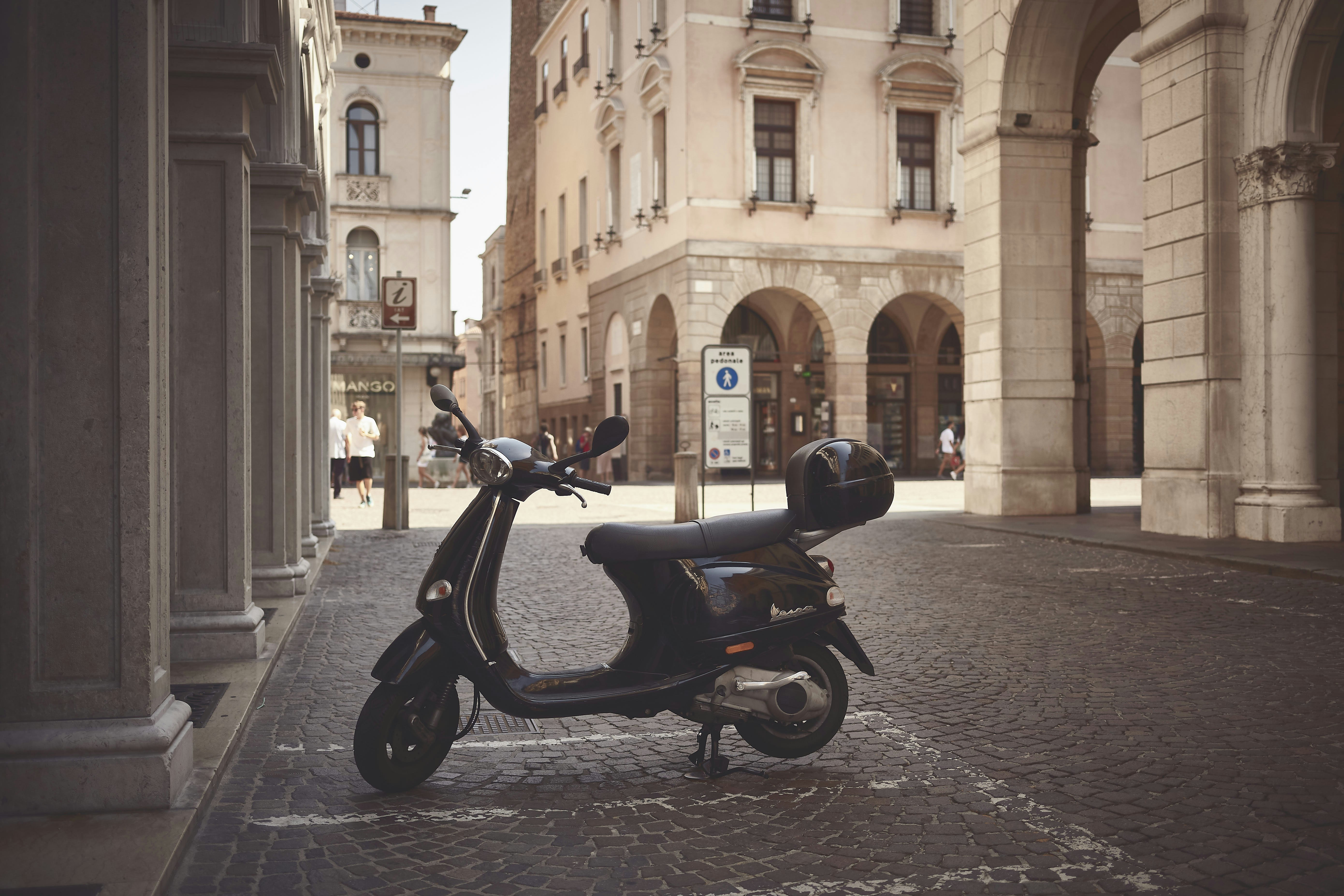 a scooter is parked on a cobblestone street