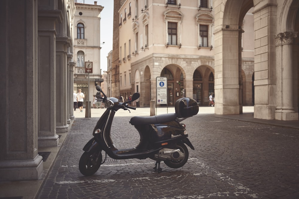 a scooter is parked on a cobblestone street