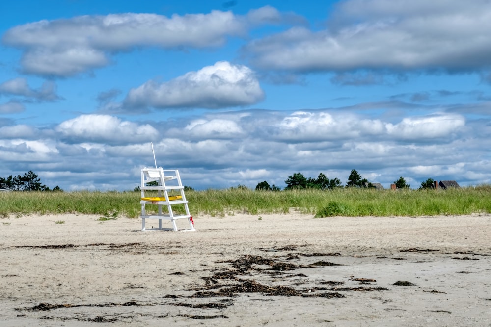 a lifeguard chair sitting on top of a sandy beach