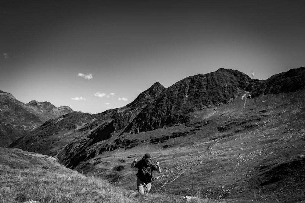 a black and white photo of a person hiking in the mountains