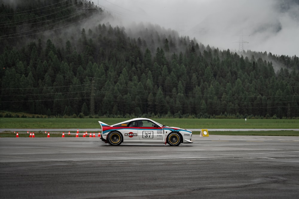 a car driving on a race track with mountains in the background