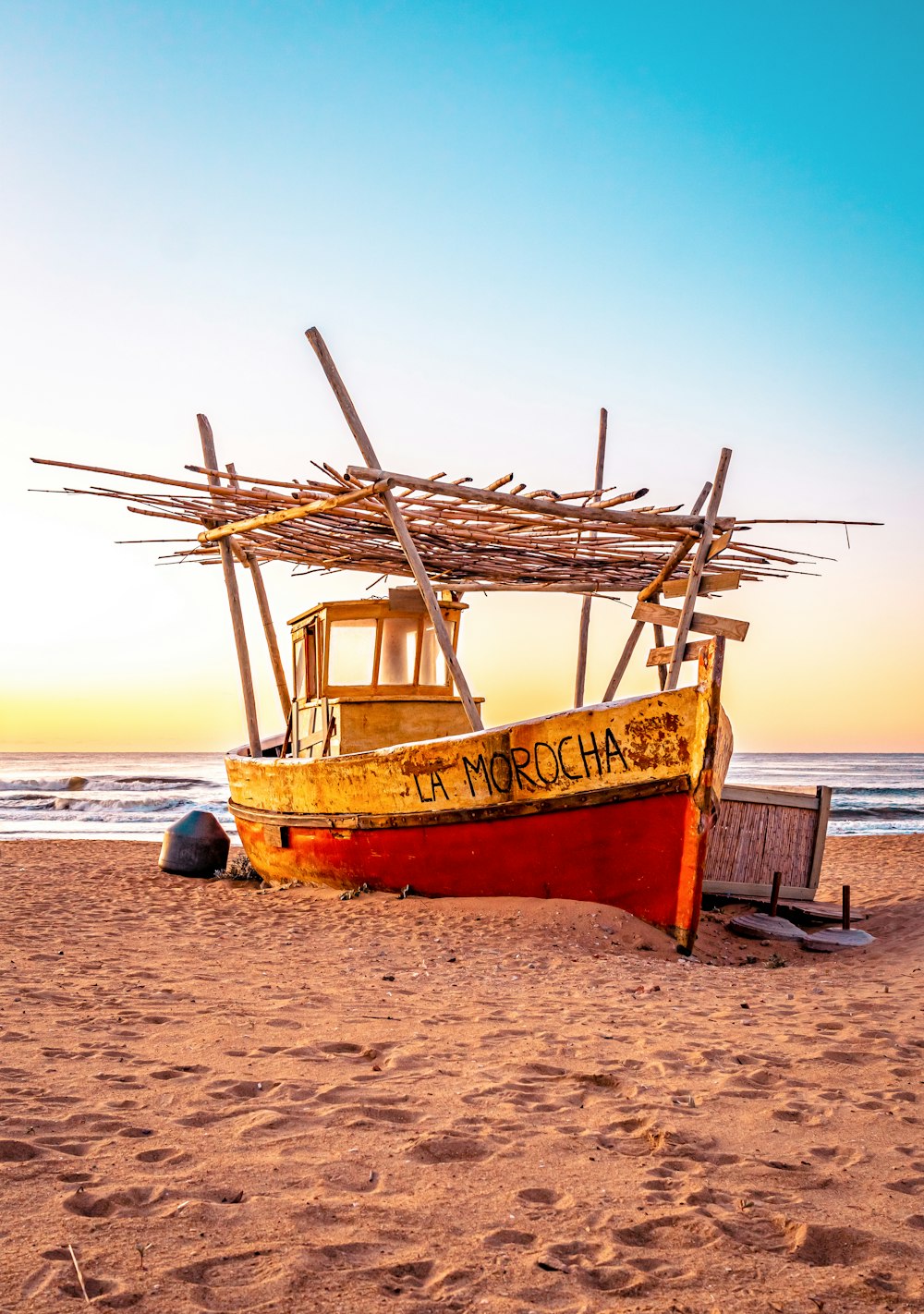 a boat sitting on top of a sandy beach