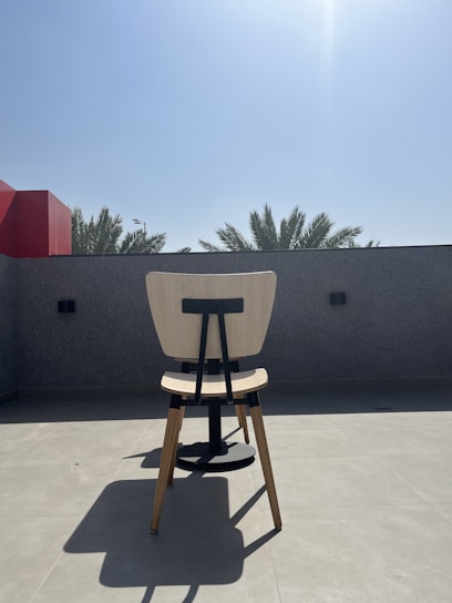 A sunlit backyard scene in Southern California with palm trees and a cozy porch chair.