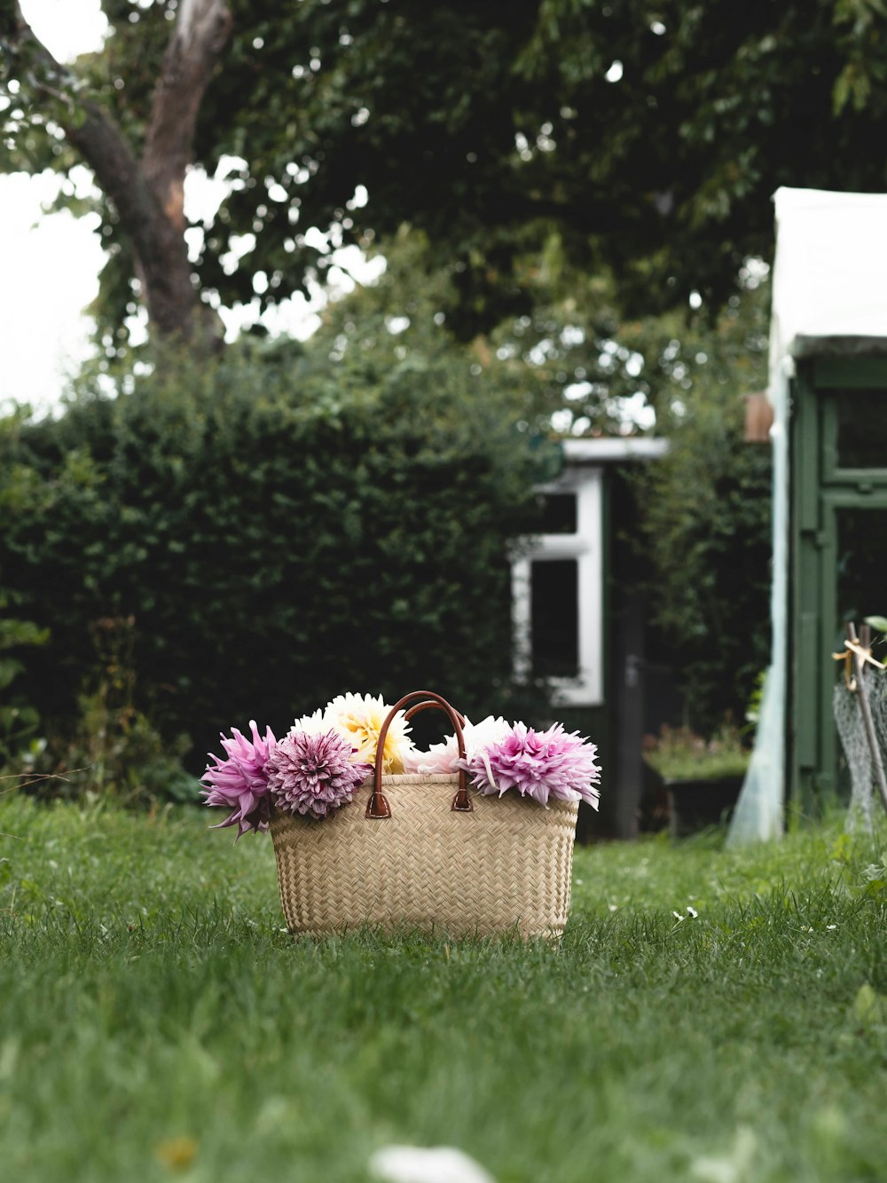 a basket with flowers in it sitting in the grass
