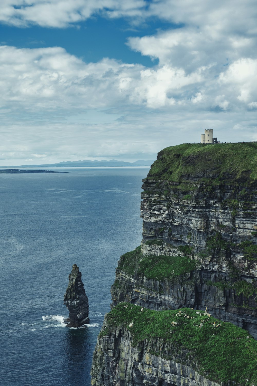 a lighthouse on a cliff overlooking the ocean