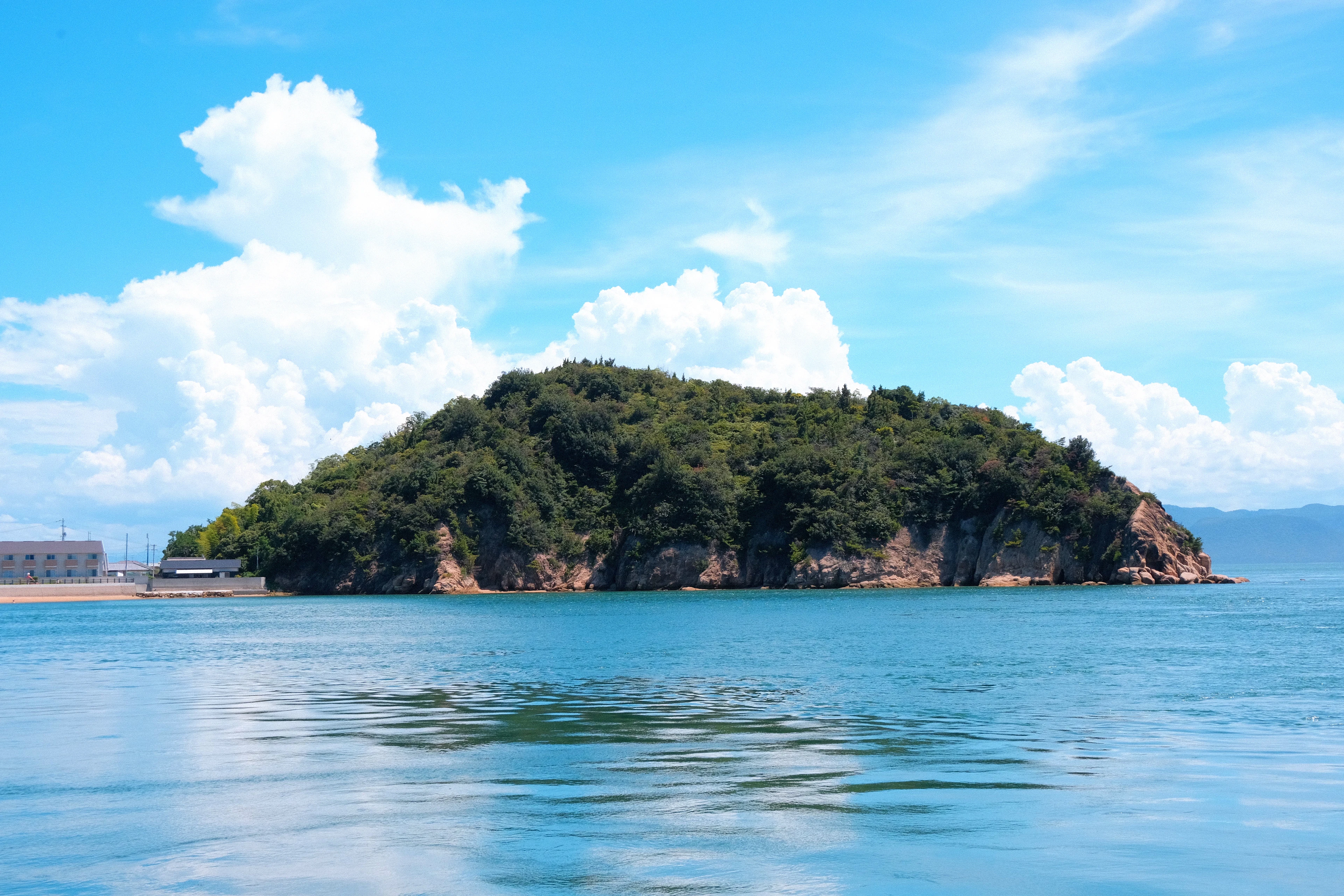 A small wooded island in the calm Seto Inland Sea off Naoshima