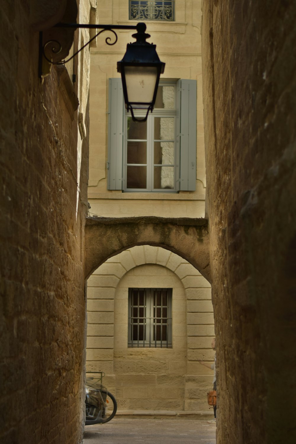 an alley way with a lamp and a bicycle