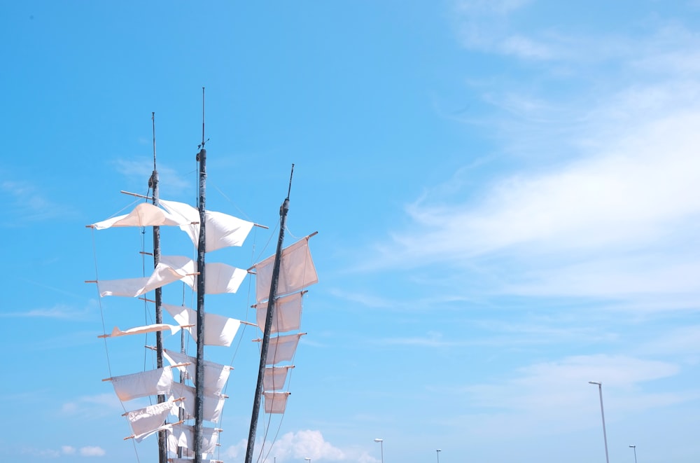 a tall white sail boat floating on top of a body of water