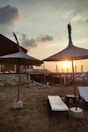 Sunset view from a beachfront terrace with lounge chairs.