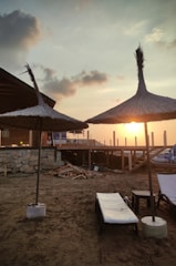 Sunset view from a beachfront terrace with lounge chairs.
