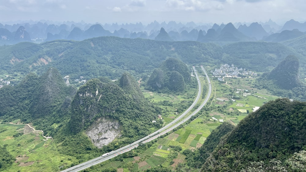 a scenic view of a road surrounded by mountains