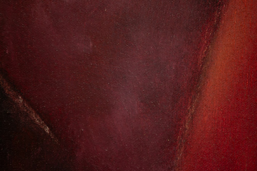 a close up of a red and black painting