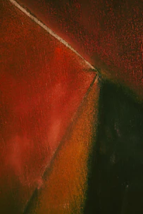 An abstract composition featuring intersecting geometric shapes with textured surfaces in rich, earthy tones. The sharp triangular form cuts across with gradients of red transitioning into dark green and orange.