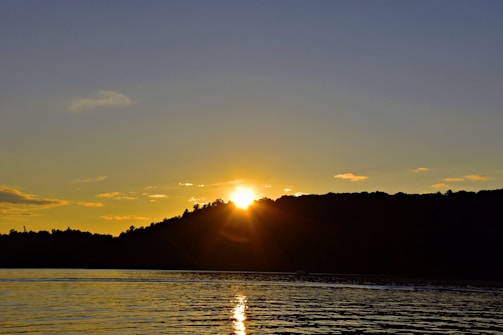 A serene landscape depicting a tranquil sunset over a calm sea.