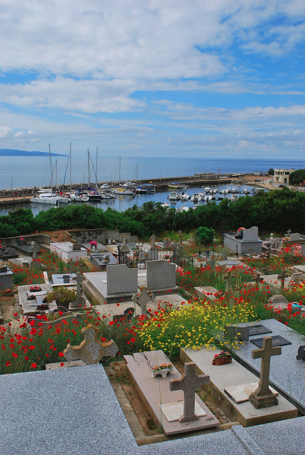 a cemetery with flowers and boats in the water
