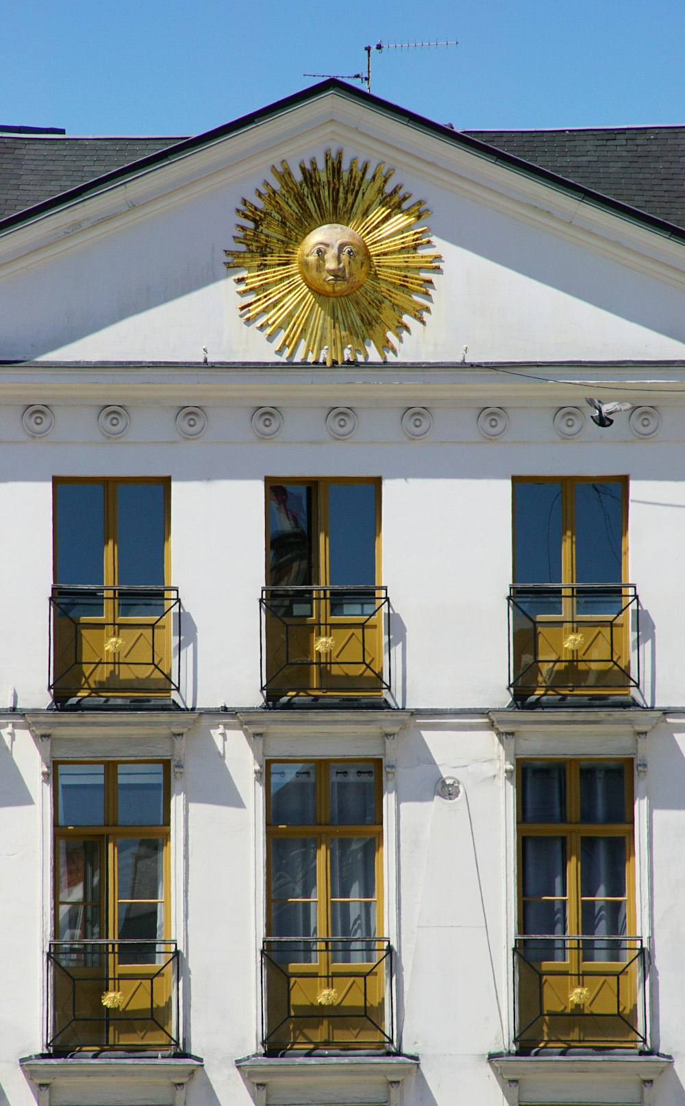 a white building with yellow balconies and windows