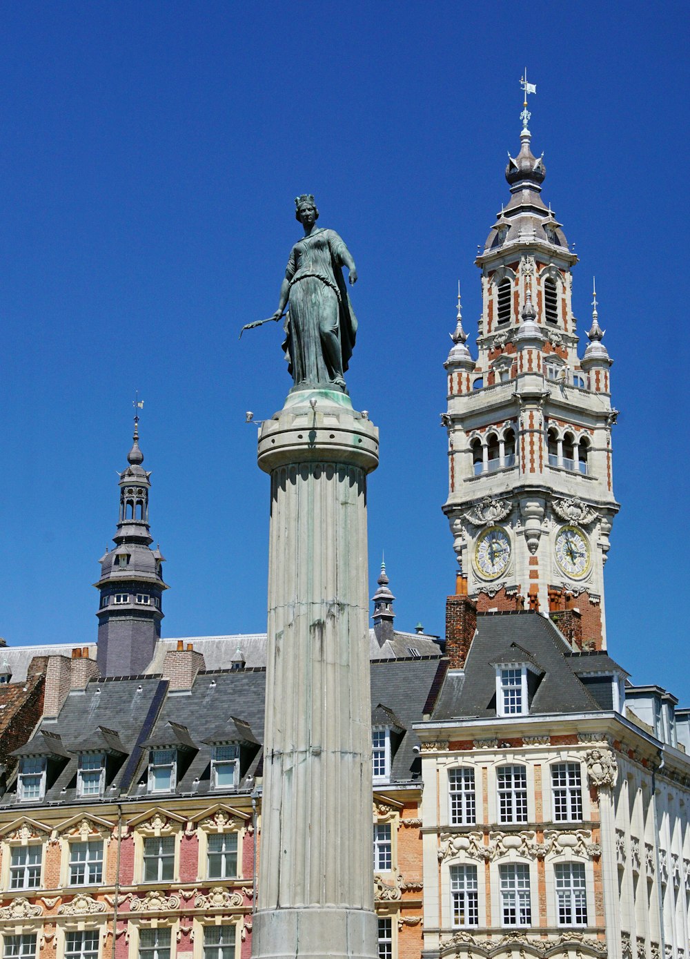 a statue stands in front of a tall building