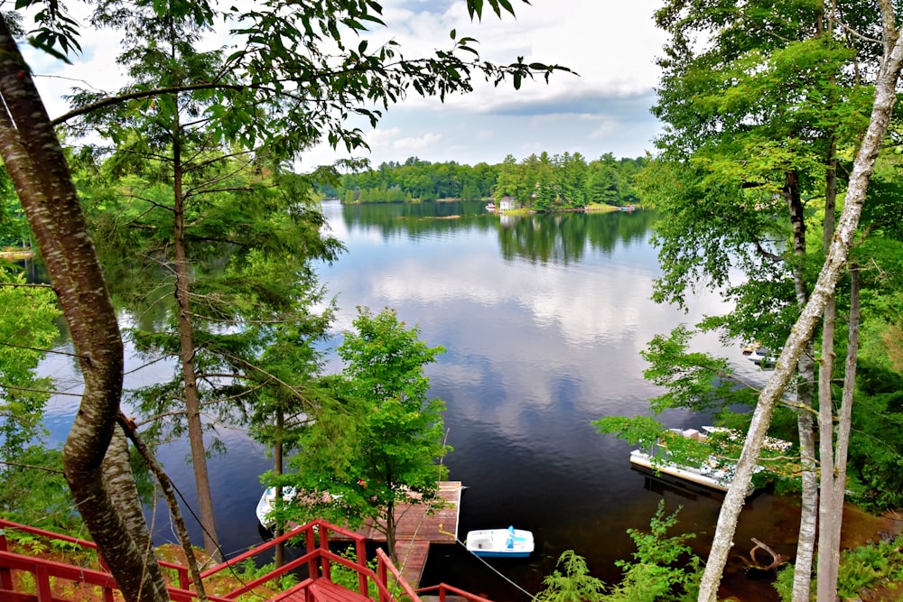 a lake surrounded by trees with a boat in the water