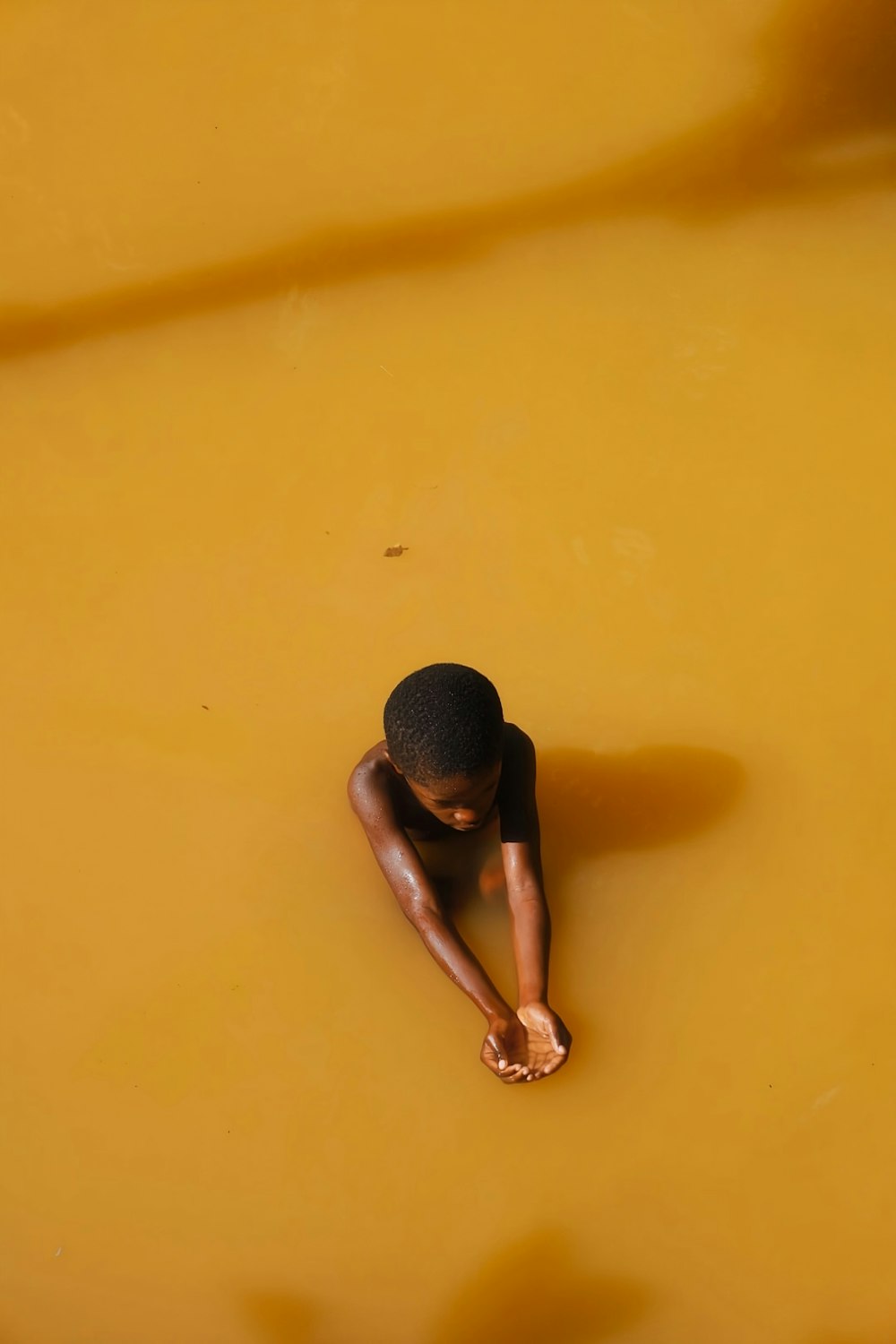 a boy is floating in a yellow pool