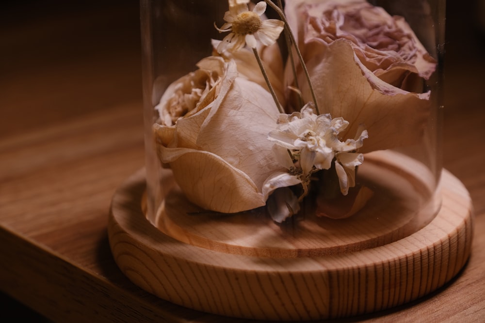 un vase avec des fleurs à l’intérieur sur une table
