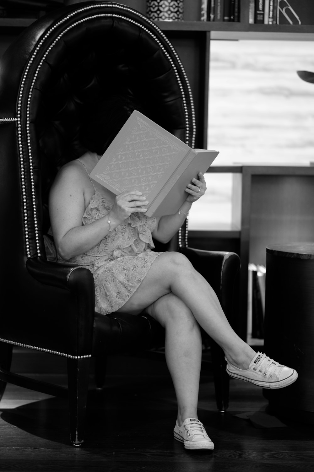 a woman sitting in a chair reading a book