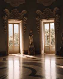 A pristine luxury living room with polished marble floors and elegant furnishings bathed in natural light.