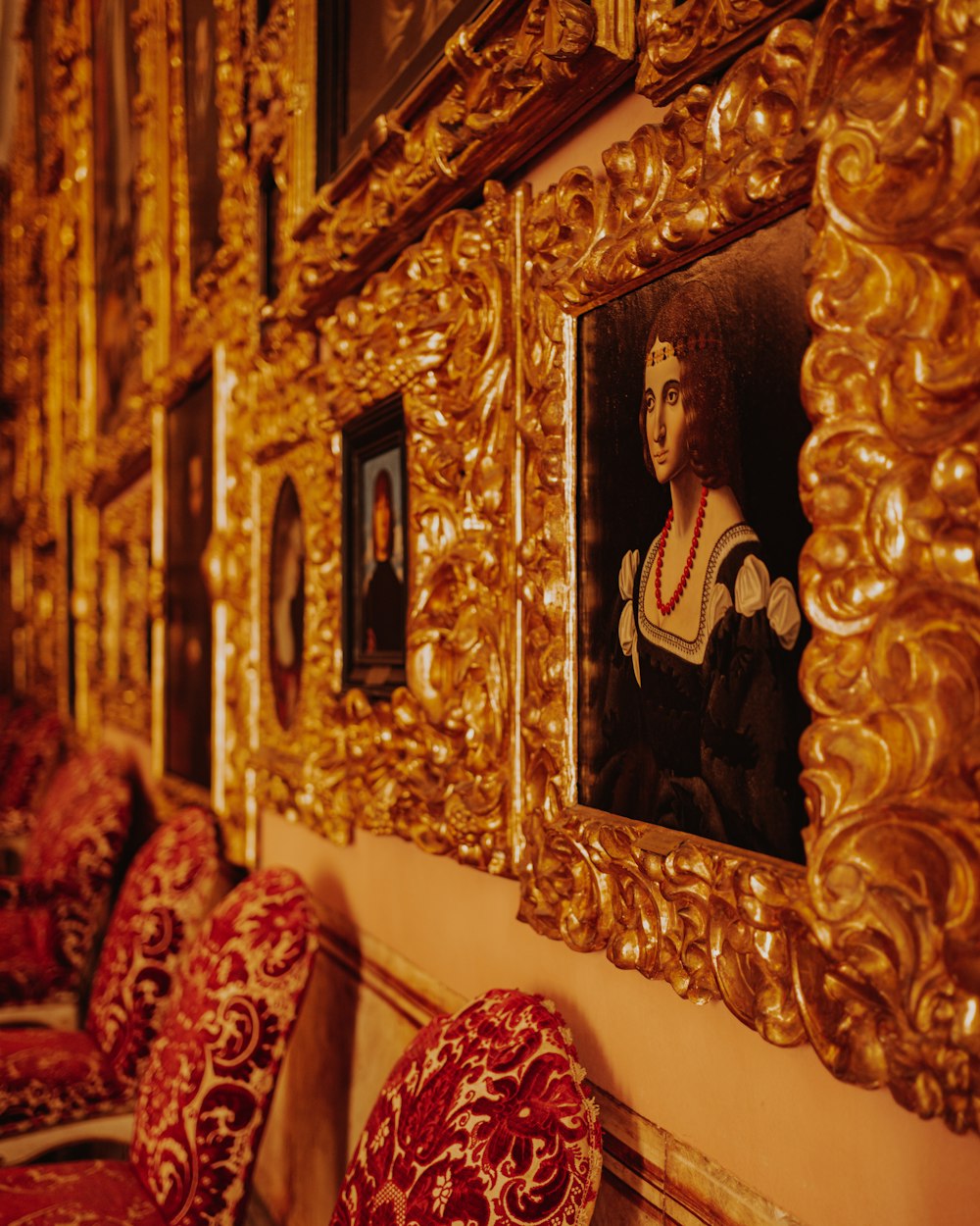 Un dipinto di una donna in una cornice d'oro su una parete