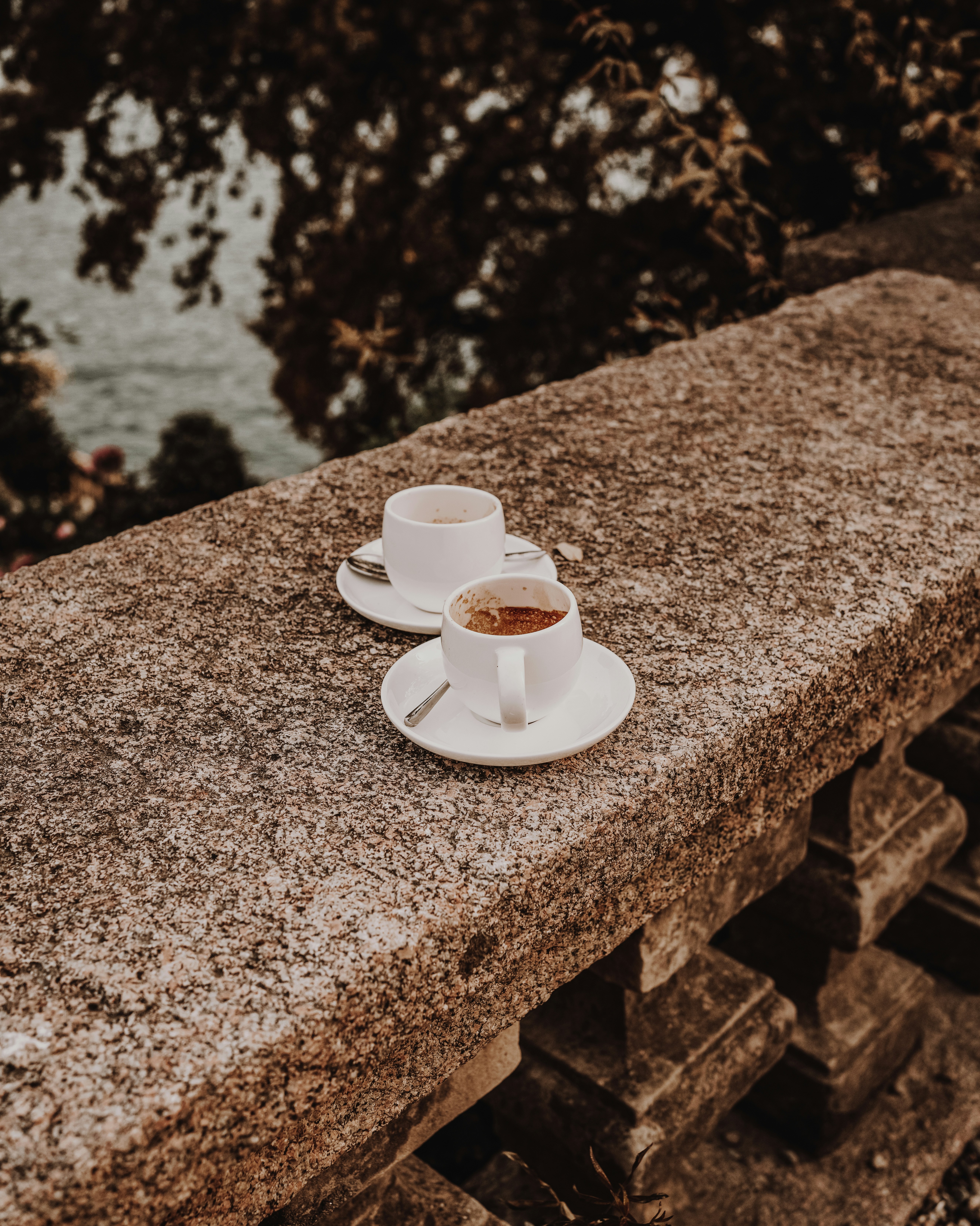 a cup of coffee sitting on top of a stone ledge