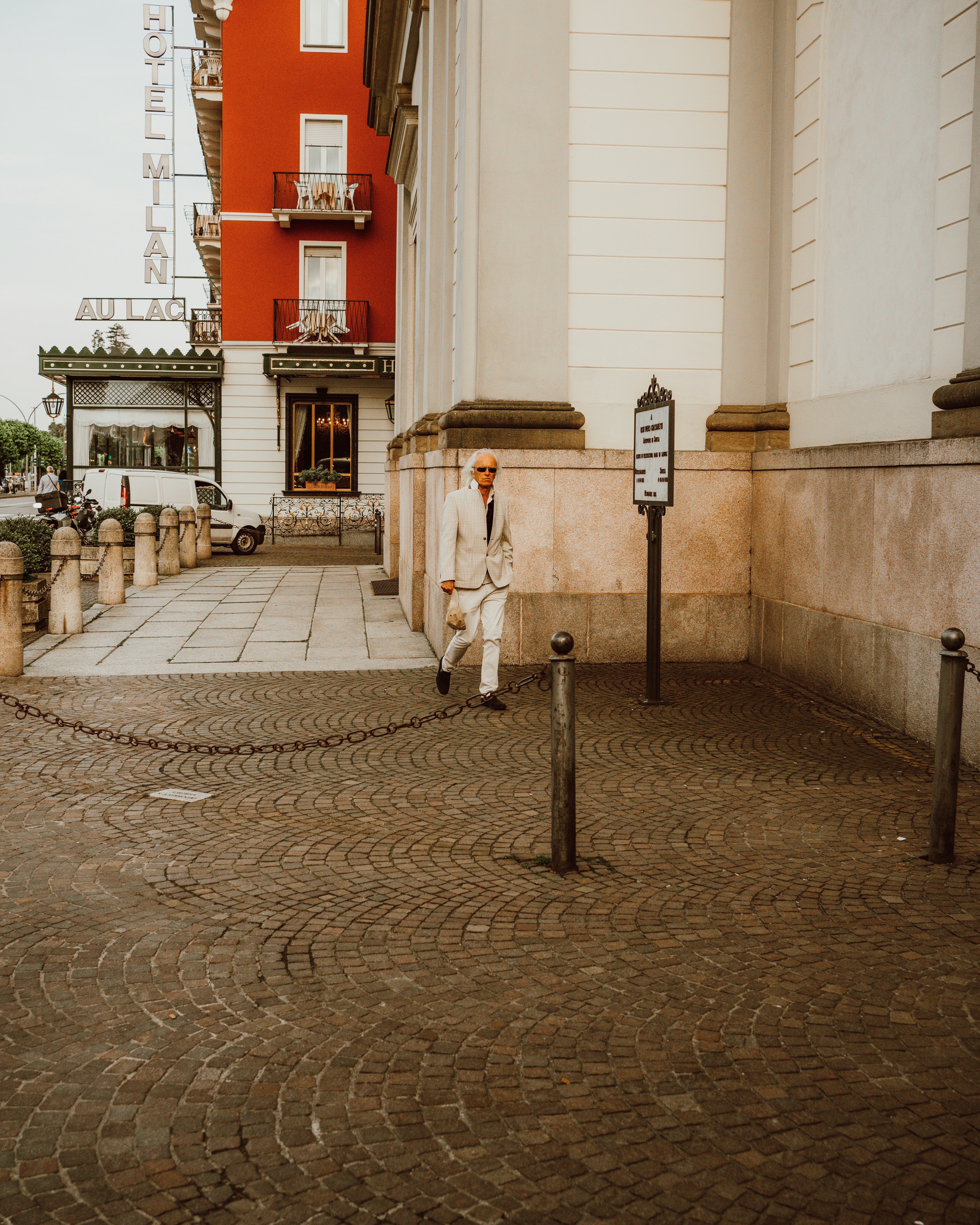 Un hombre con un traje blanco parado frente a un edificio foto – Imagen ...