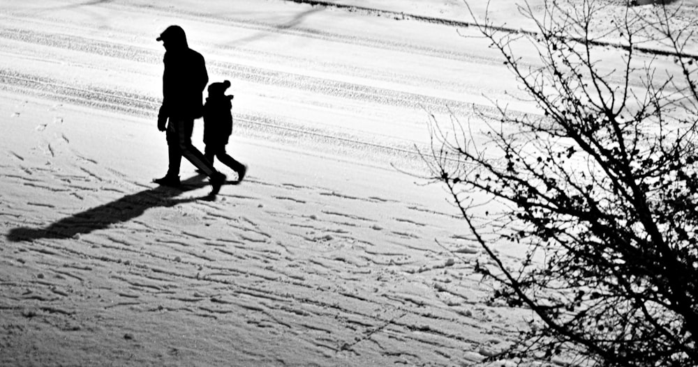 a person and a child walking in the snow