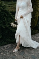 A model wearing a glamorous wedding dress on a scenic outdoor setting.