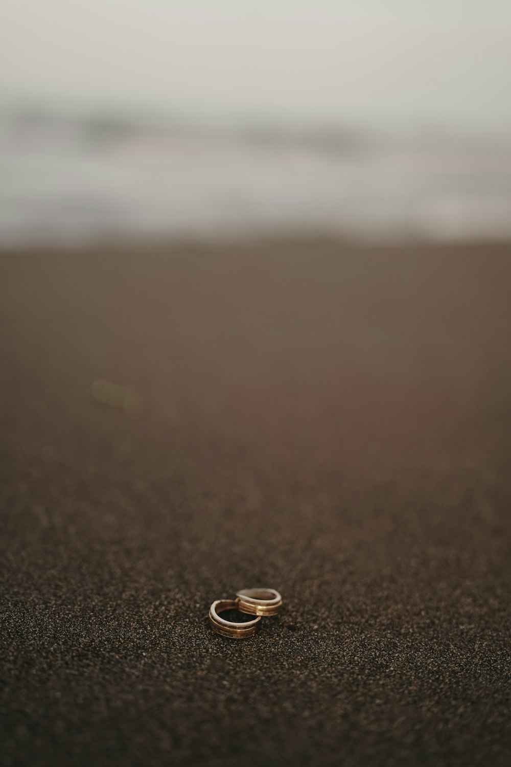 a couple of rings sitting on top of a sandy beach