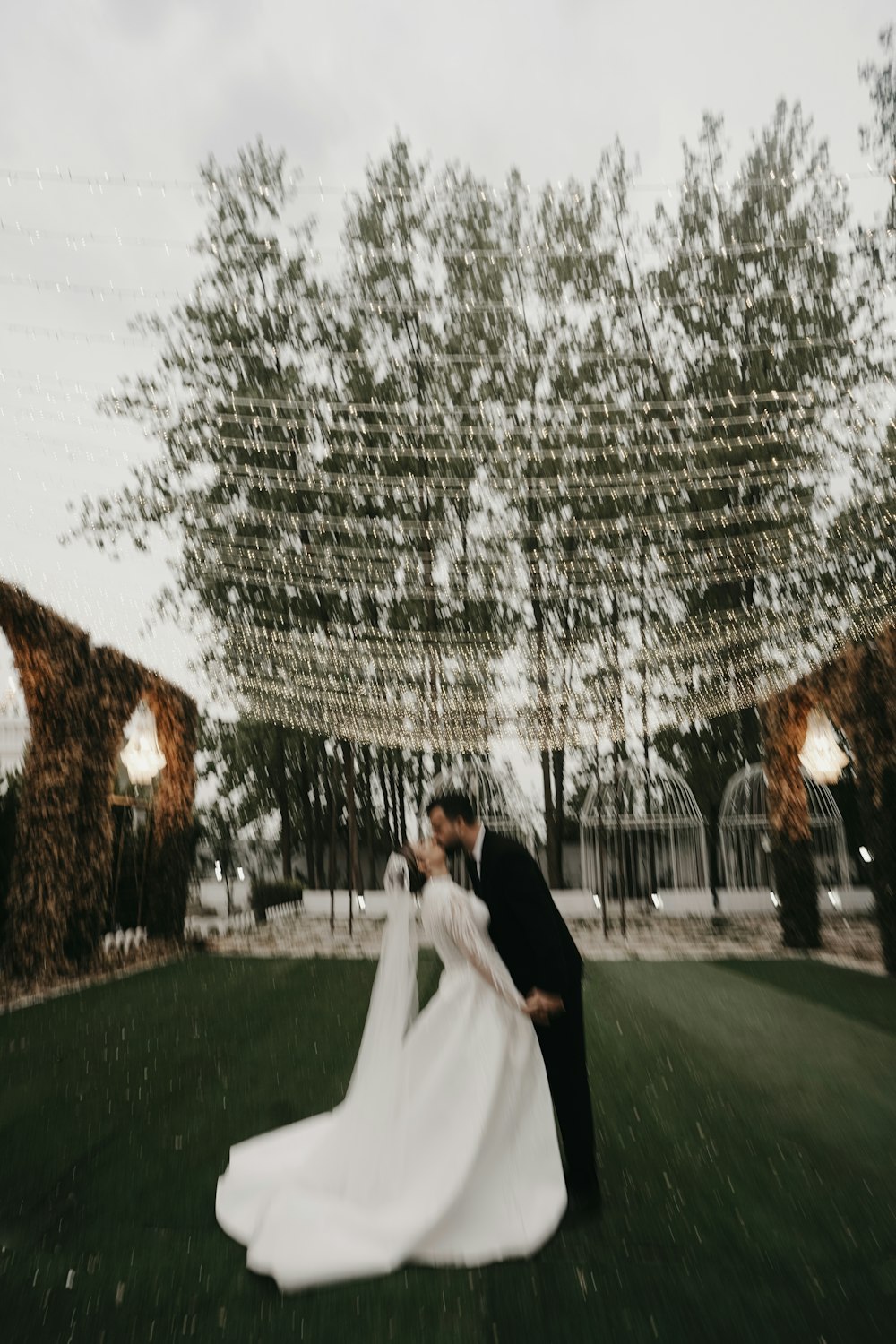 a bride and groom kissing in front of a tree