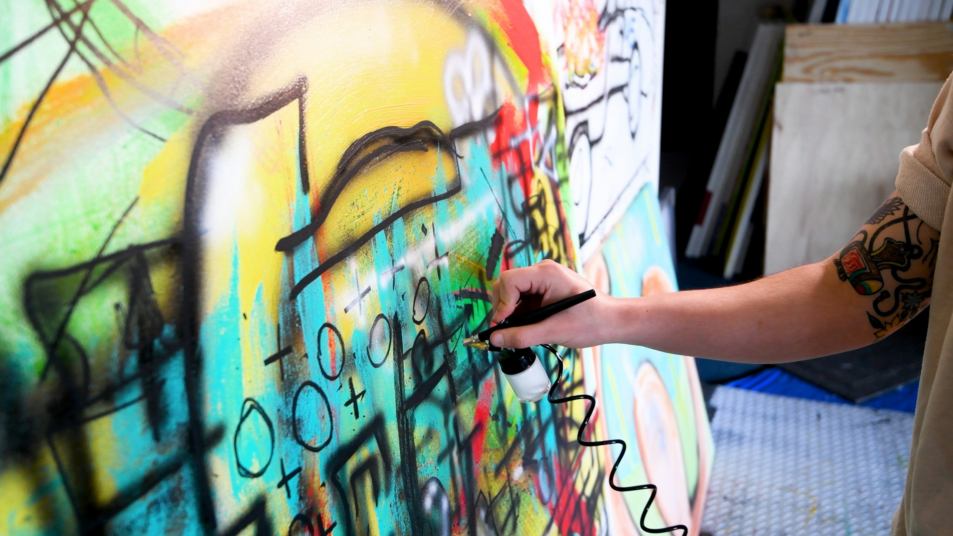 a person painting a wall with colorful graffiti