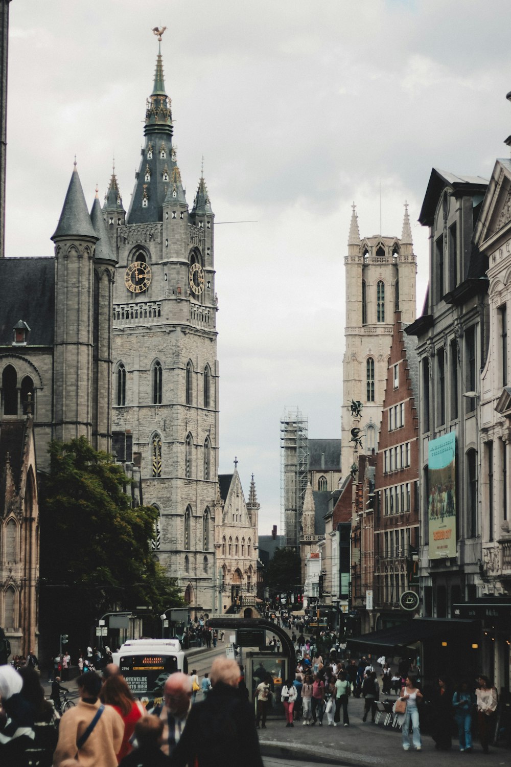 a crowd of people walking down a street next to tall buildings