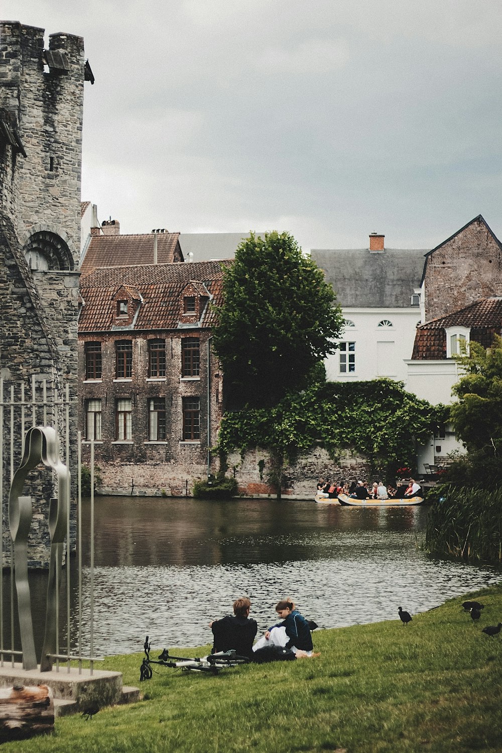 a group of people sitting next to a body of water