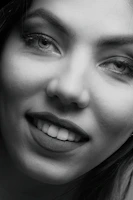 Close-up portrait of a woman with a deceptive smile, symbolizing a scammer.