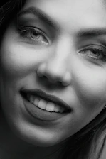 Close-up of a confident woman with a mysterious smile, inviting connection.