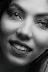 Close-up of a confident woman with a mysterious smile, inviting connection.