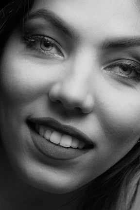 Close-up of a confident woman with a mysterious smile, highlighting her elegance.
