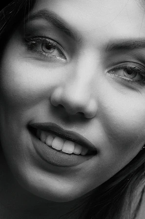 Close-up portrait of a woman with a deceptive smile, symbolizing a scammer.
