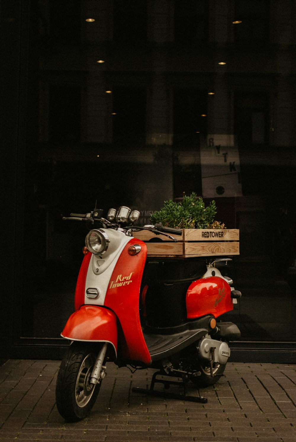 a red scooter is parked in front of a building