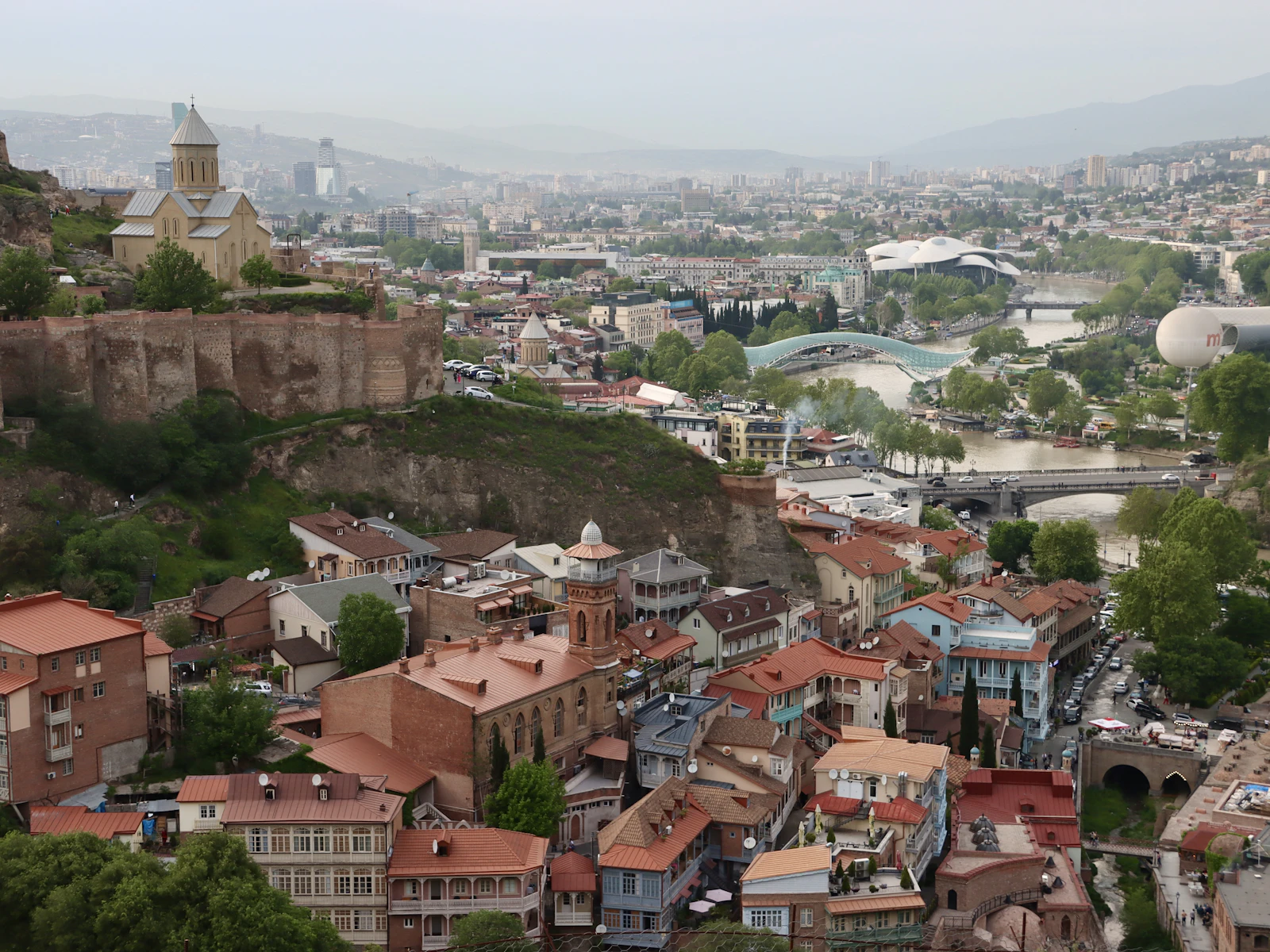 The tiled roofs of old Tbilisi below the Narikala ridge, with the modern city beyond