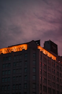 a tall building with a neon sign on top of it