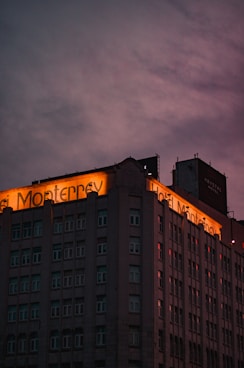 a tall building with a neon sign on top of it