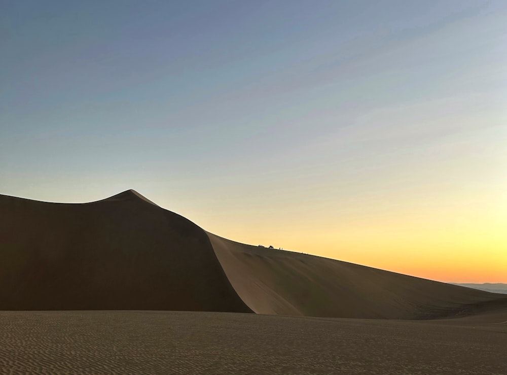 El sol se está poniendo sobre las dunas de arena