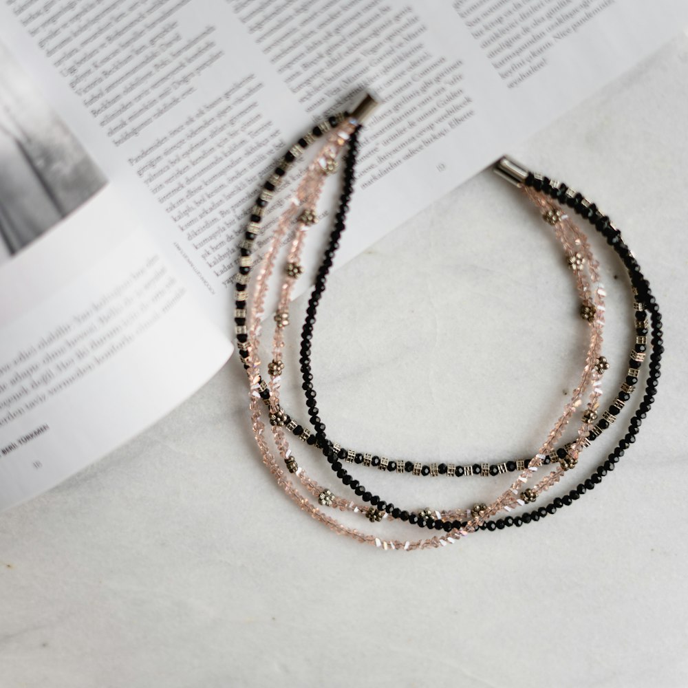 a stack of beaded necklaces sitting on top of a book