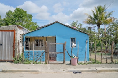 Modern single-family home with a bright blue door and manicured front yard in San Diego.