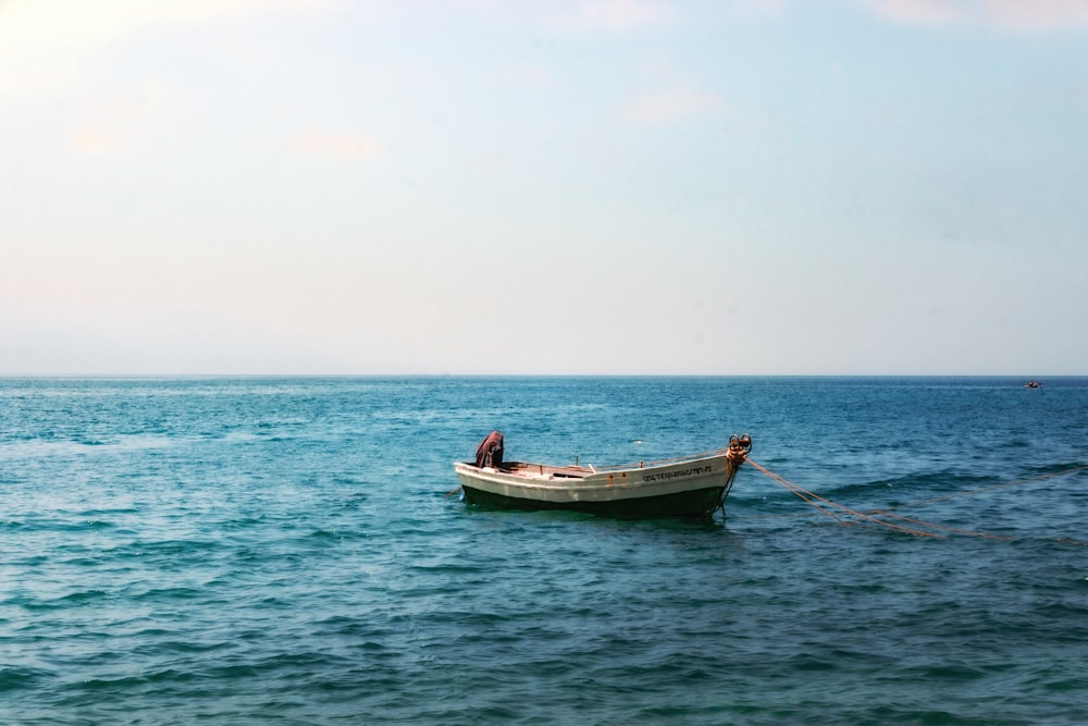 a small boat floating on top of a large body of water