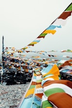 A serene Bhutanese mountain landscape with a traveler admiring prayer flags fluttering in the breeze.